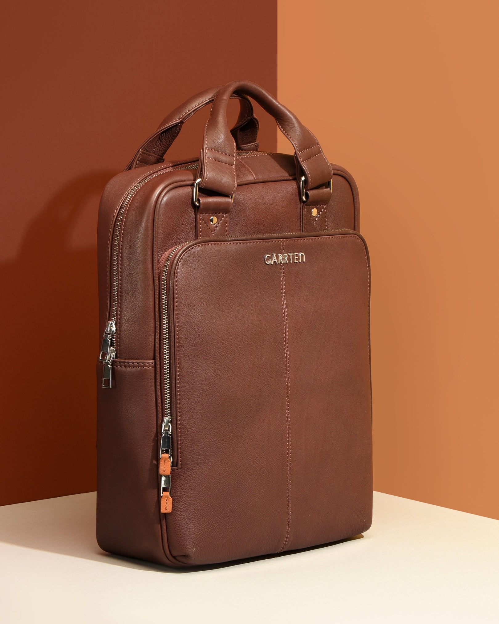 Vintage Mahogany Brown: tilt view of Garrten signature convertible full grain leather backpack