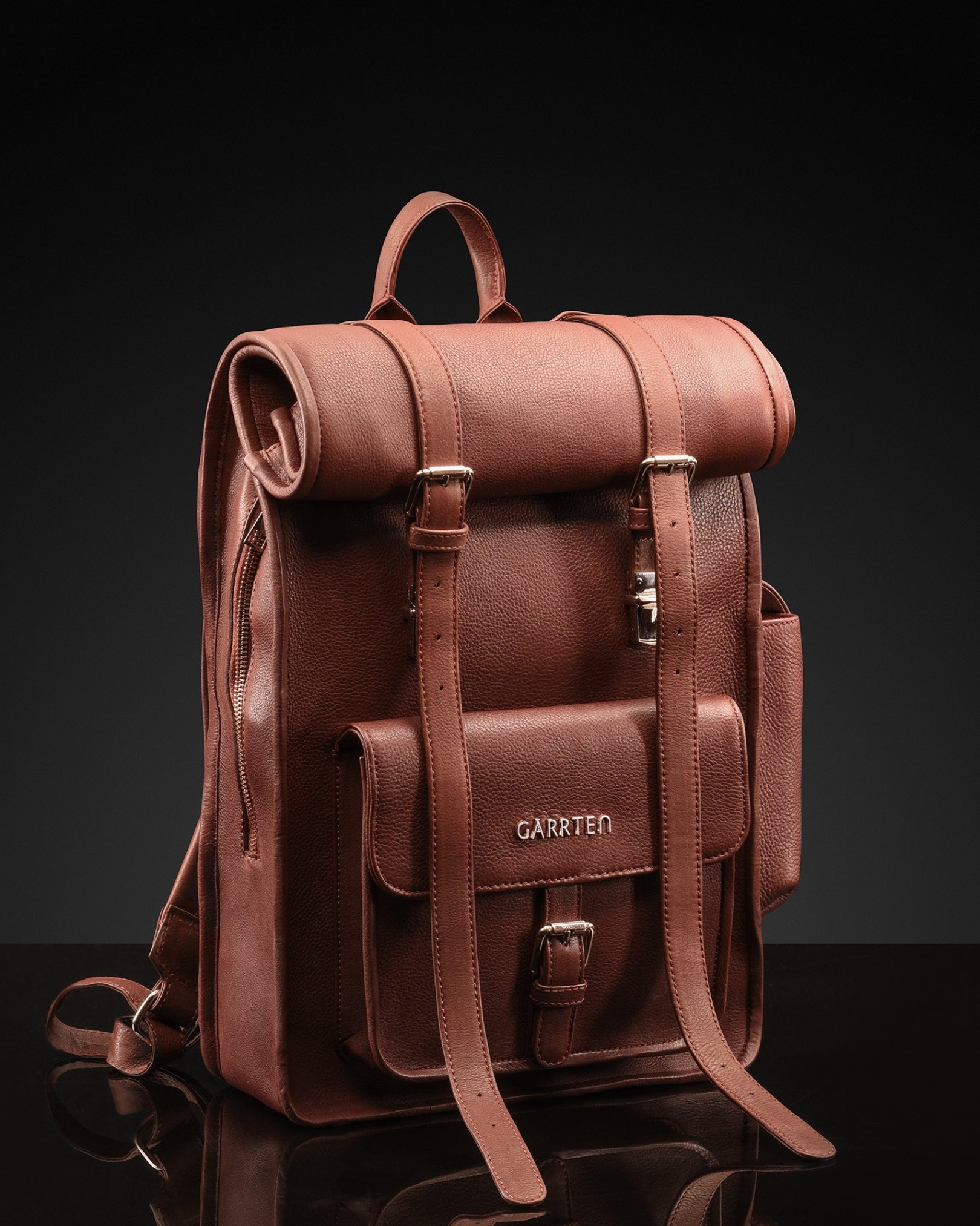 intage Mahogany Brown: tilted front view of Garrten rolltop style full grain leather backpack with top rolled up closure