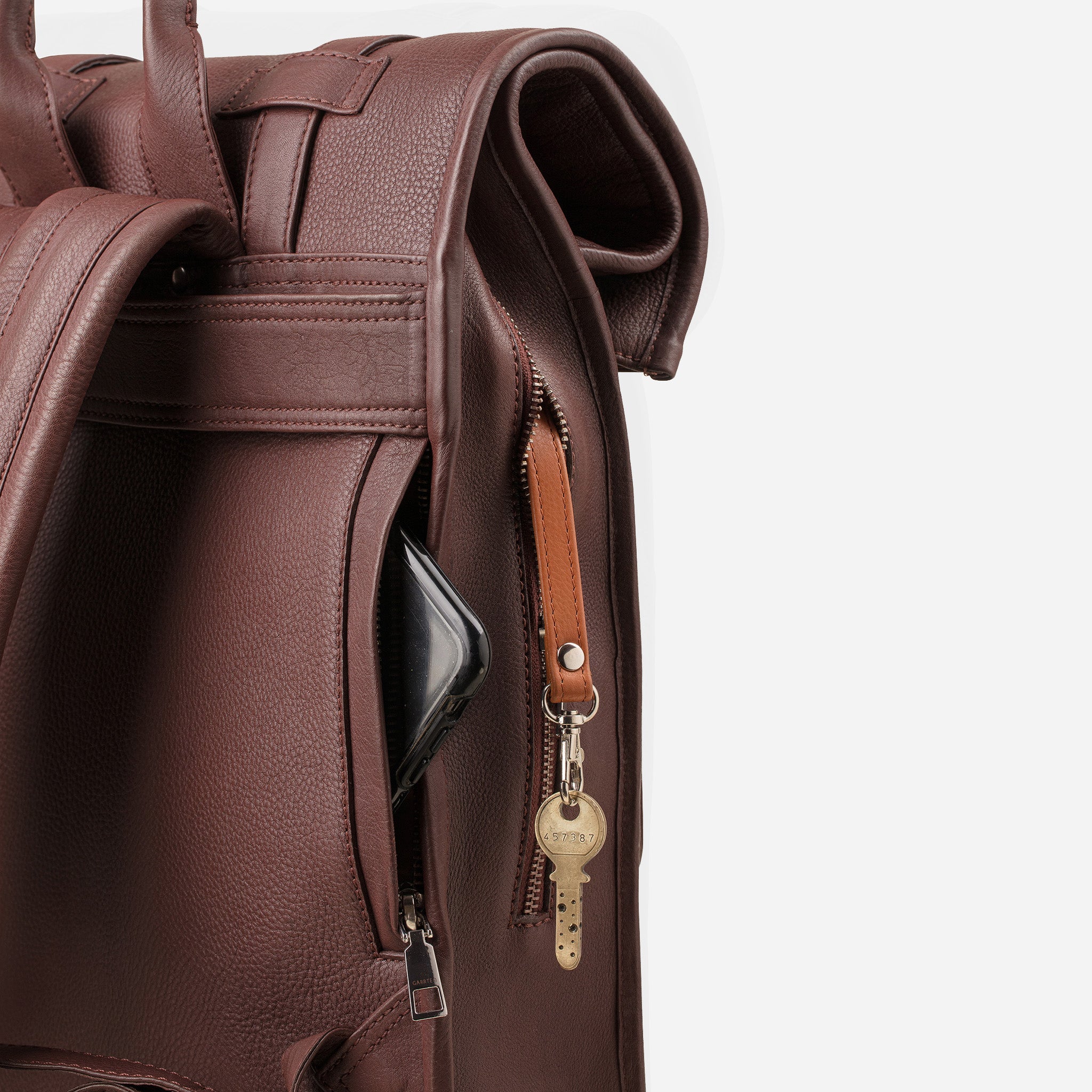 Vintage Mahogany Brown: back view showing quick access pocket and keychain strap of Garrten rolltop style full grain leather backpack