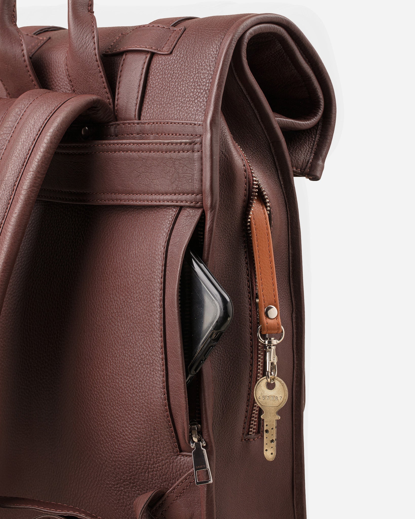Vintage Mahogany Brown: back view showing quick access pocket and keychain strap of Garrten rolltop style full grain leather backpack