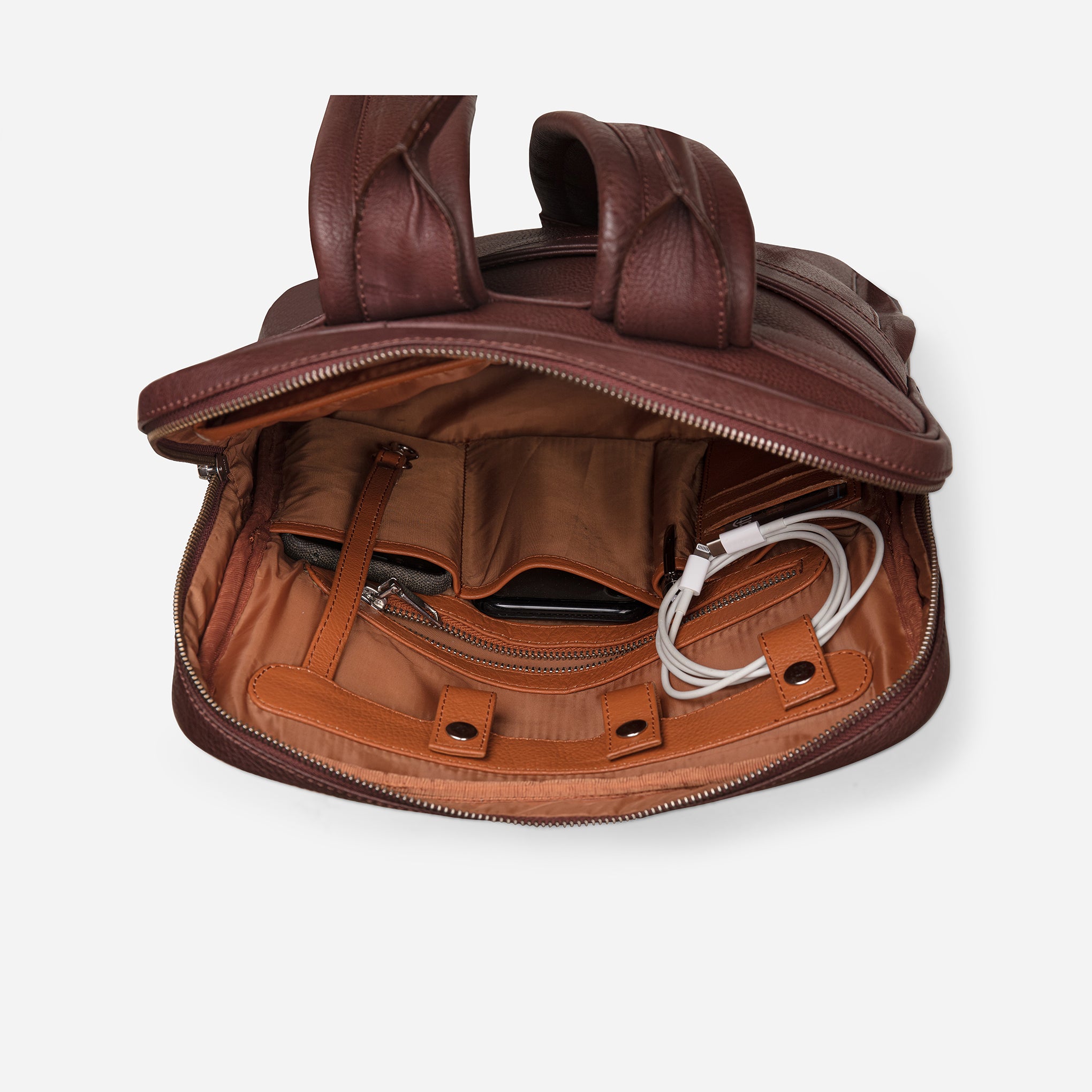 Vintage Mahogany Brown: top inside view showing cable loops, zipper pocket & multi pockets of Garrten slim full grain leather backpack
