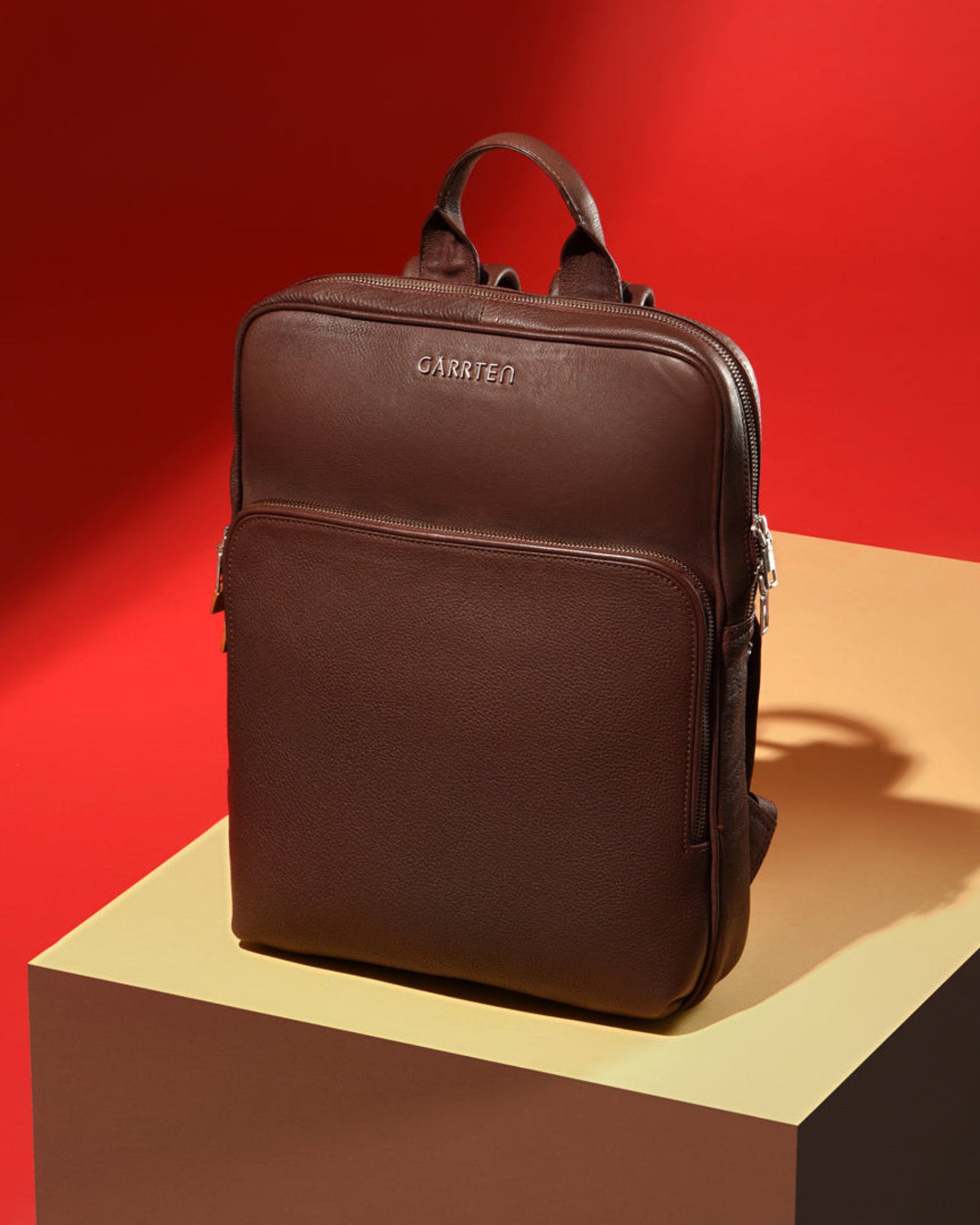 GARRTEN 731 slim full-grain leather backpack in vintage mahogany brown — second hero lifestyle mood shot showing sleek silhouette against neutral background