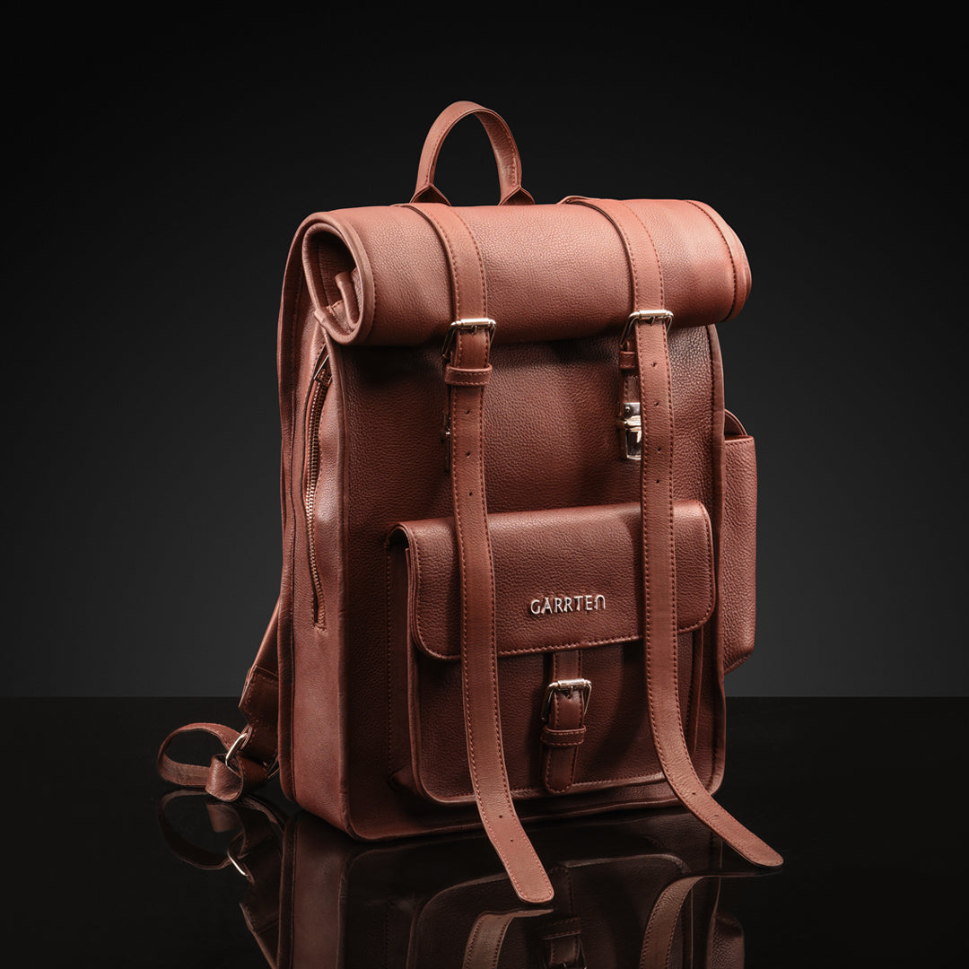 Vintage Mahogany Brown: tilted front view of Garrten rolltop style full grain leather backpack with top rolled up closure