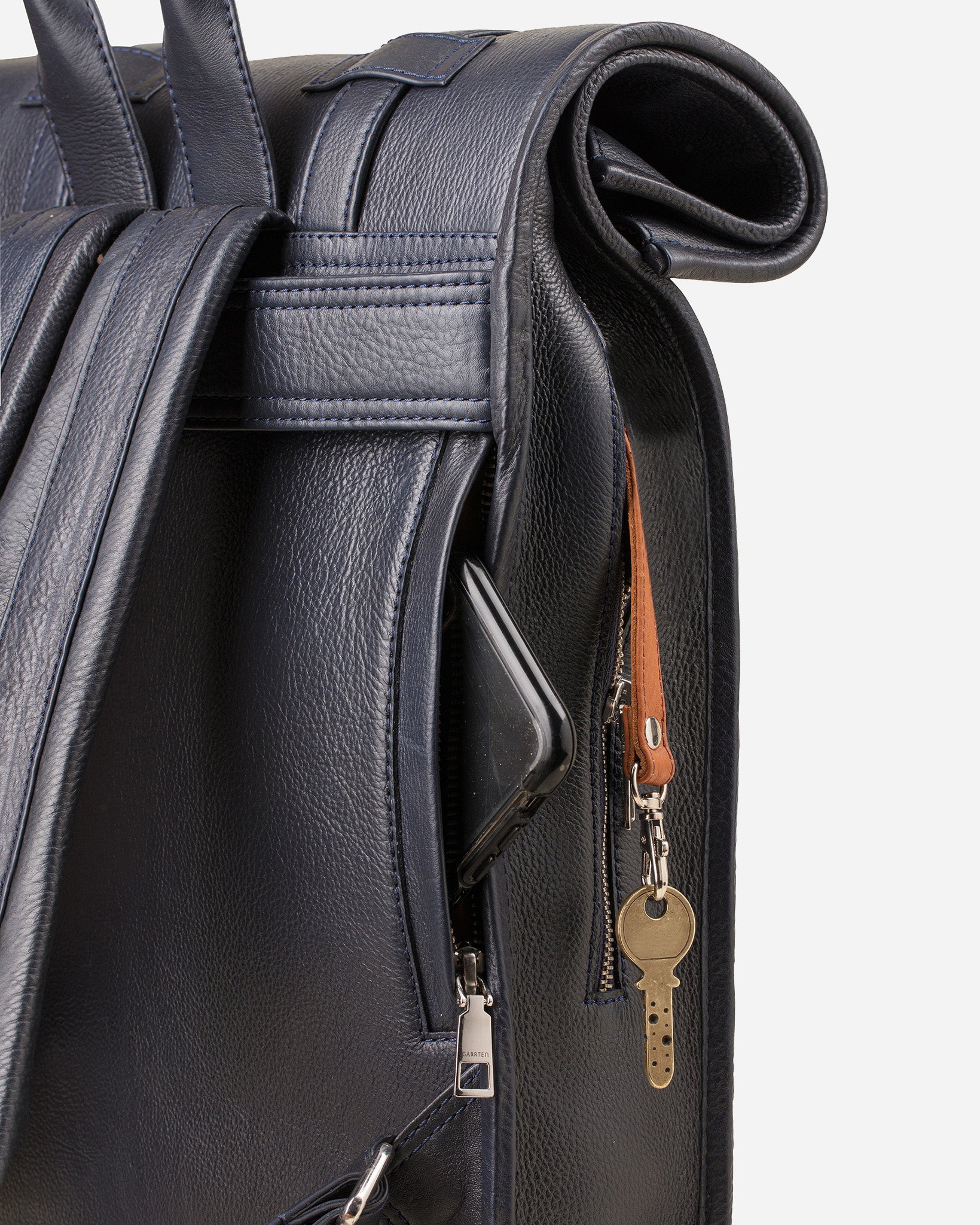 Midnight Blue: back view showing quick access pocket and keychain strap of Garrten's rolltop style full grain leather backpack
