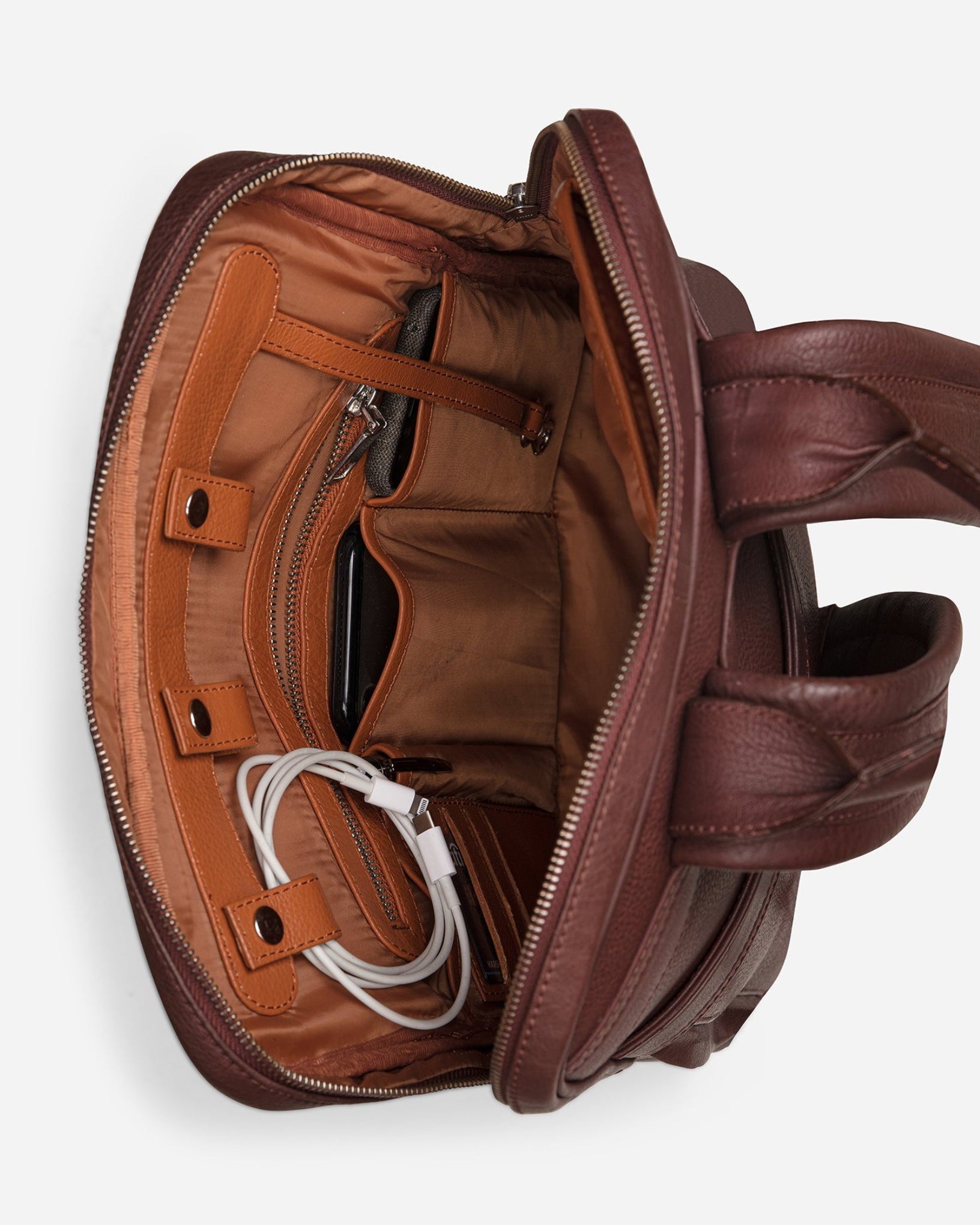 Vintage Mahogany Brown: top inside view showing cable loops, zipper pocket & multi pockets of Garrten slim full grain leather backpack